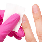 Hand wearing a pink glove holding a white cotton pad against a white background